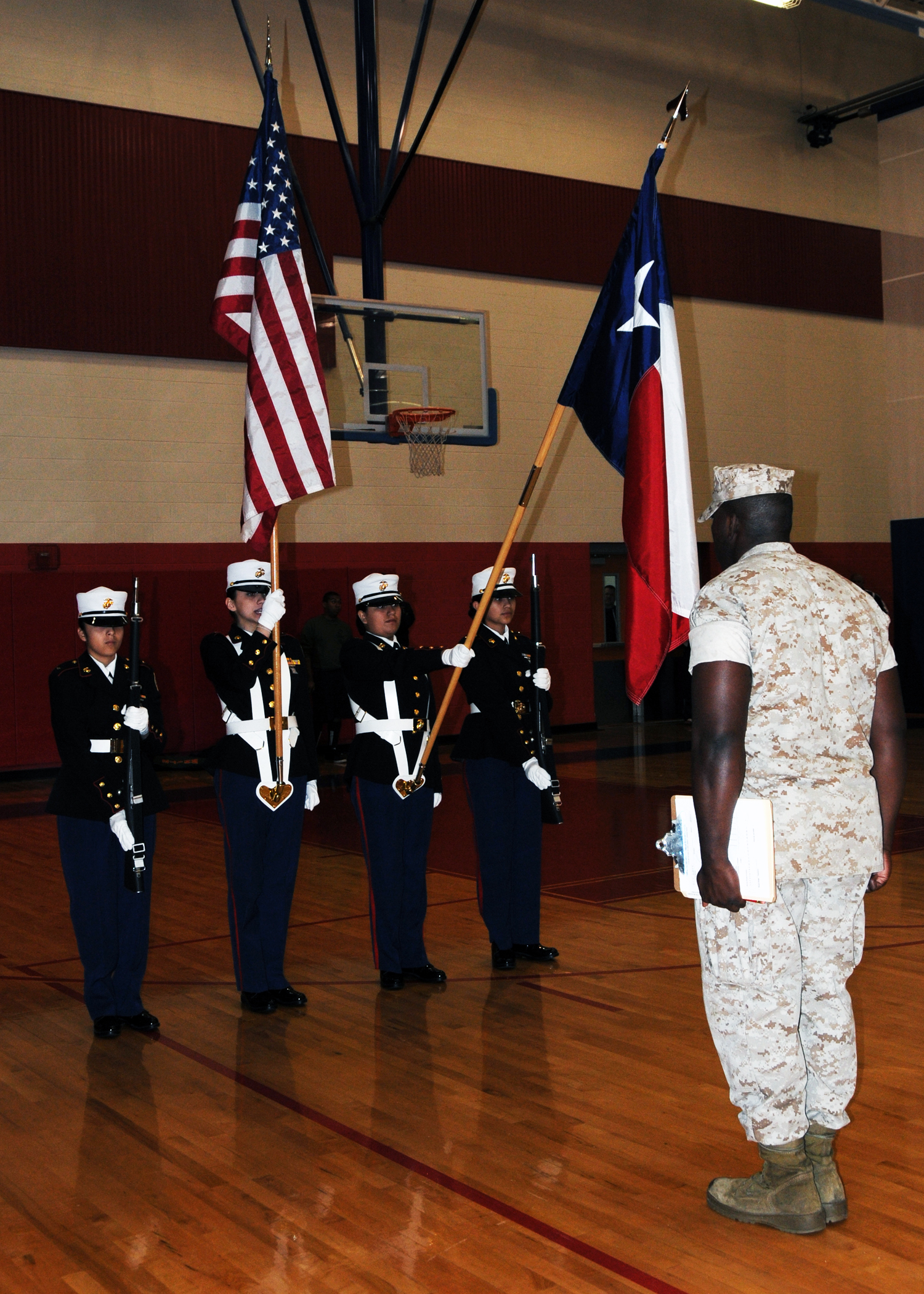 Sgt. Timothy Craig, right, a recruiter from Marine Corps Recruiting Station San Antonio, Recruiting Sub-Station Austin North, grades the W.T. White High School Marine Corps Junior Reserve Officer Training Corps female color guard team at an all-Marine JROTC competition at Jack C. Hays High School, in Buda, Texas, March 5, 2011.